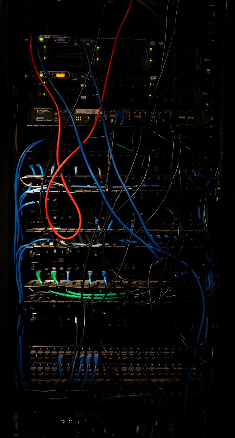 Server rack with tangled blue and red network cables.